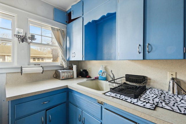 kitchen with blue cabinetry, light countertops, and a sink