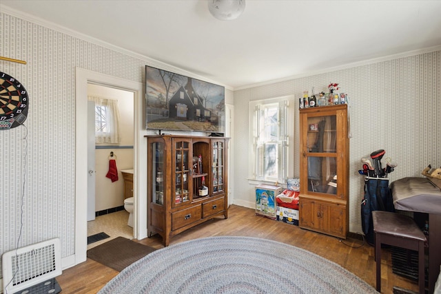 interior space with wallpapered walls, crown molding, baseboards, and wood finished floors