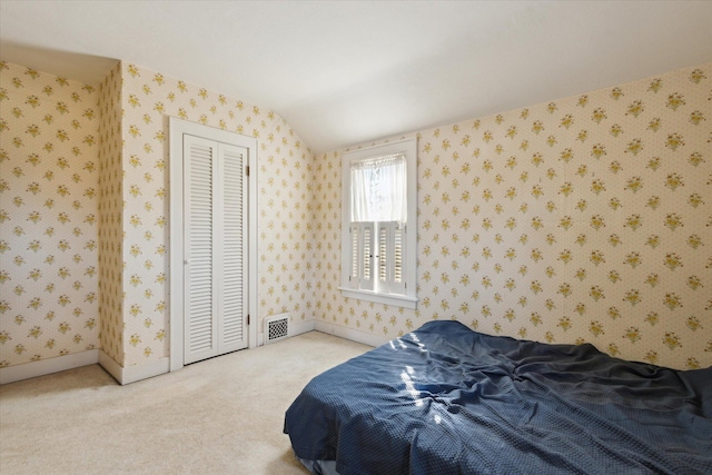 bedroom with visible vents, wallpapered walls, baseboards, vaulted ceiling, and carpet flooring