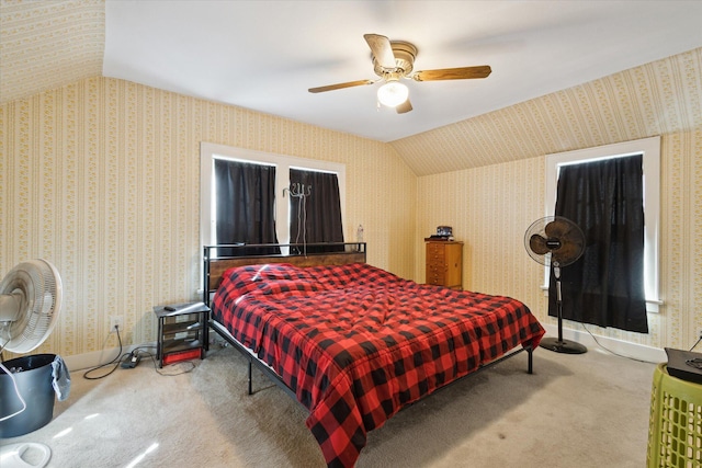 carpeted bedroom featuring ceiling fan, wallpapered walls, baseboards, and vaulted ceiling