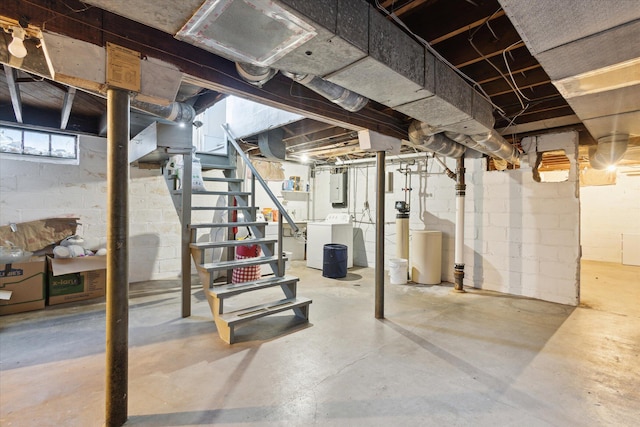 below grade area featuring electric panel, washing machine and dryer, and stairs