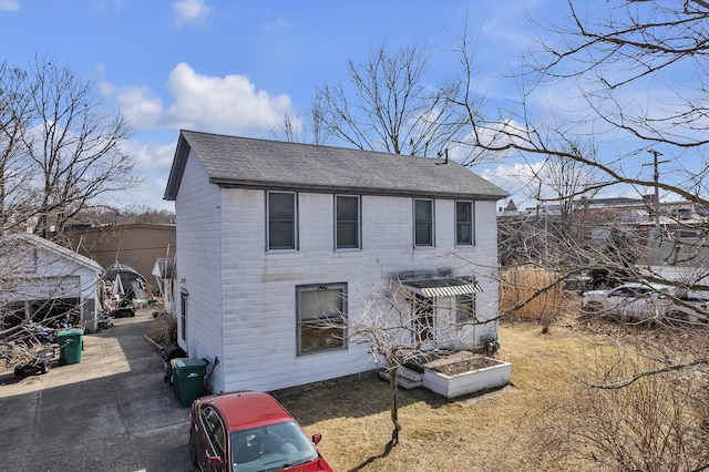 view of front of home featuring a front yard and roof with shingles