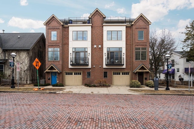 townhome / multi-family property with brick siding, concrete driveway, and a garage