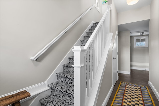 stairs with wood finished floors and baseboards