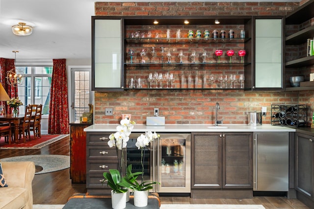 bar with a sink, wood finished floors, wine cooler, stainless steel fridge, and wet bar