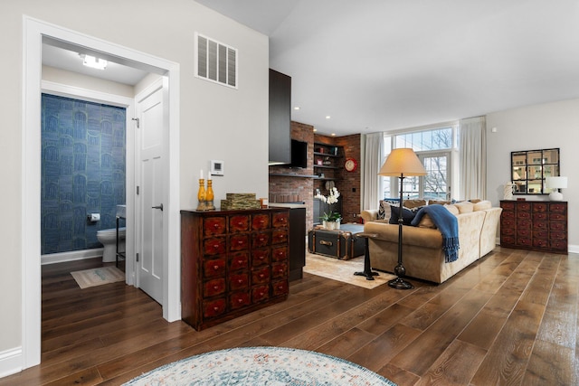 living room featuring visible vents, wood-type flooring, and baseboards