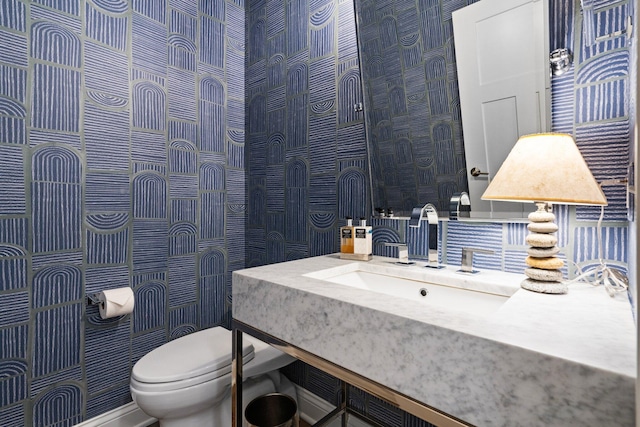 bathroom with vanity, tile walls, and toilet