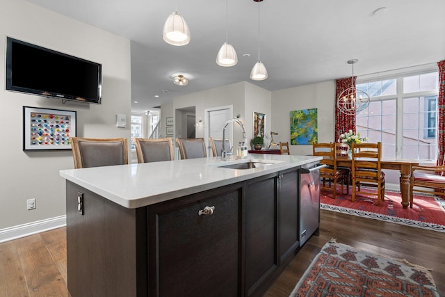 kitchen with dark wood-style floors, a healthy amount of sunlight, light countertops, and a sink