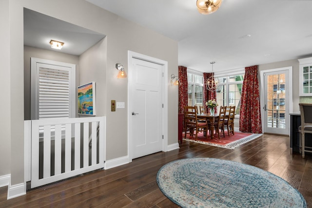 entrance foyer featuring an inviting chandelier, baseboards, and wood-type flooring