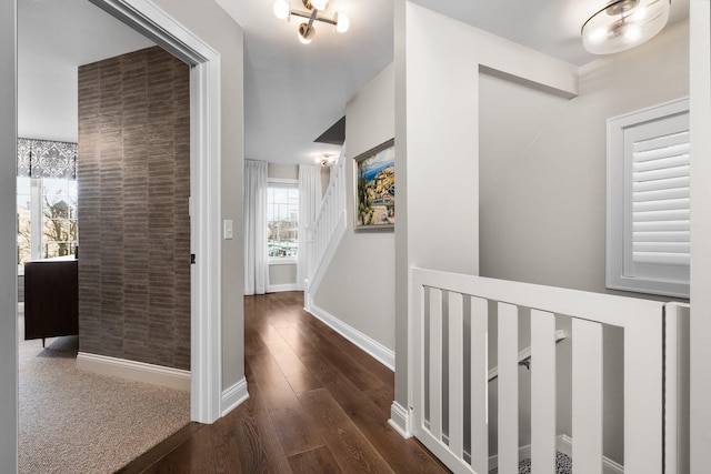 corridor with baseboards and wood finished floors