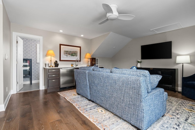 living area with dark wood-type flooring, a ceiling fan, recessed lighting, baseboards, and vaulted ceiling