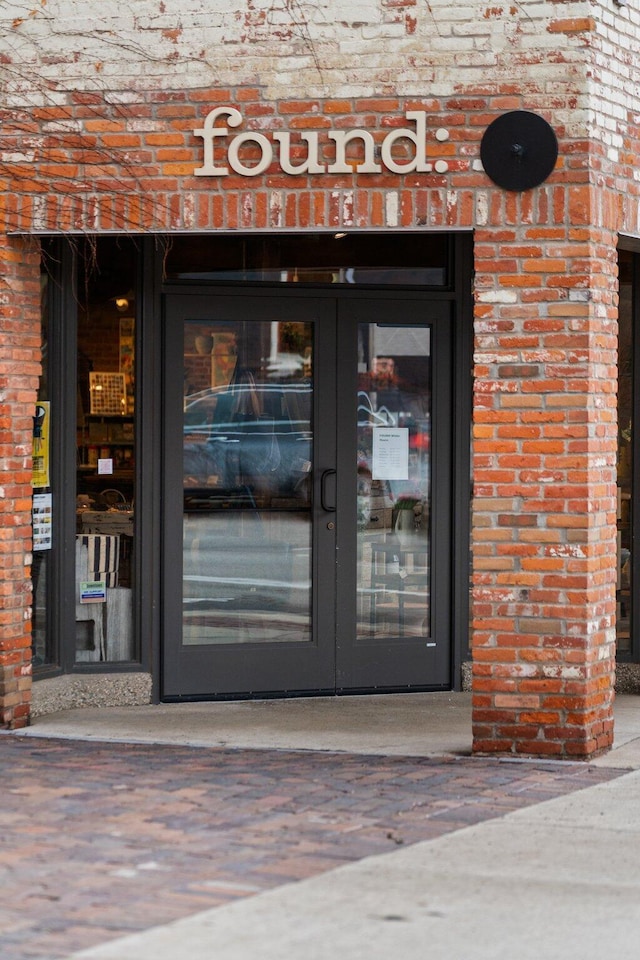 doorway to property featuring french doors and brick siding