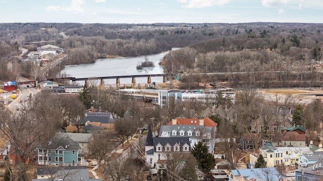 birds eye view of property with a water view and a wooded view