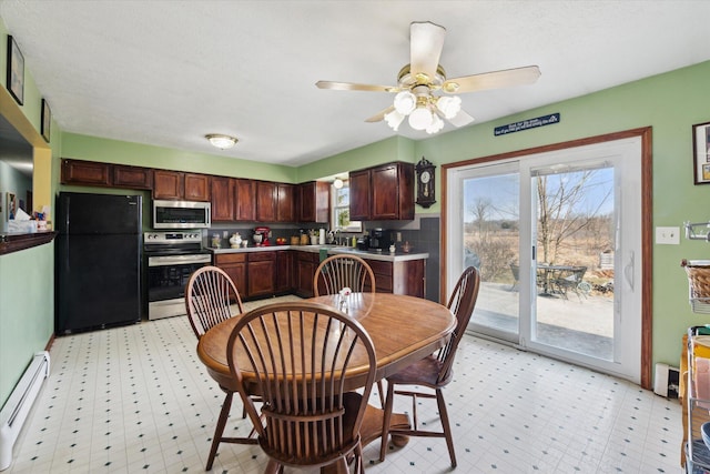 dining room featuring a baseboard radiator, light floors, and a ceiling fan