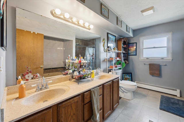 bathroom featuring a sink, toilet, a tile shower, and a baseboard radiator