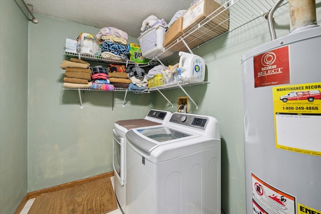 laundry room featuring baseboards, washing machine and clothes dryer, laundry area, a textured ceiling, and gas water heater