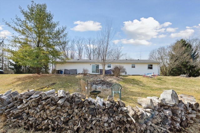 back of property featuring a lawn and a fire pit