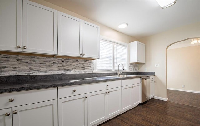 kitchen featuring a sink, tasteful backsplash, white cabinetry, dishwasher, and dark wood-style flooring