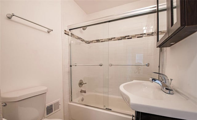 full bath with vanity, toilet, visible vents, and combined bath / shower with glass door