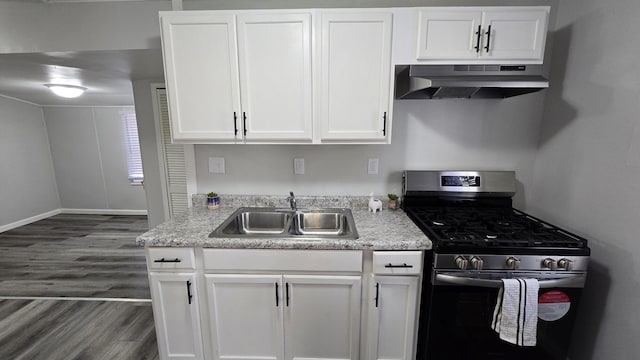 kitchen with dark wood-style floors, a sink, under cabinet range hood, white cabinetry, and gas range