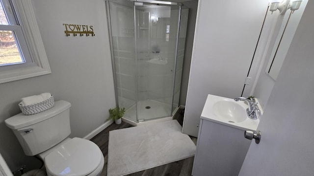 bathroom featuring vanity, a shower stall, toilet, and baseboards