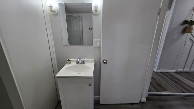 bathroom with a textured ceiling, wood finished floors, and vanity