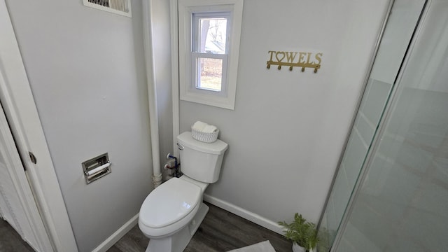 bathroom with visible vents, toilet, baseboards, and wood finished floors