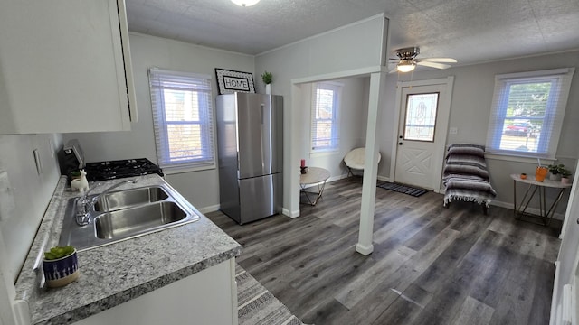 kitchen featuring dark wood-type flooring, light countertops, freestanding refrigerator, and a sink