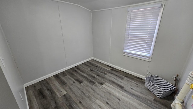 spare room featuring baseboards and wood finished floors