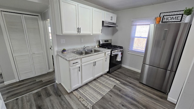 kitchen featuring under cabinet range hood, dark wood-style flooring, stainless steel appliances, and a sink