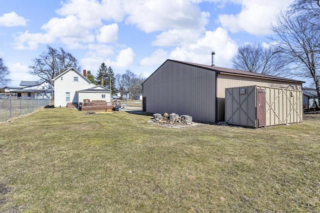 view of yard with an outdoor structure, fence, a pole building, and a wooden deck