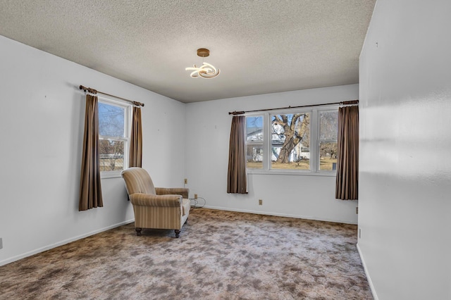 unfurnished room with carpet, baseboards, and a textured ceiling