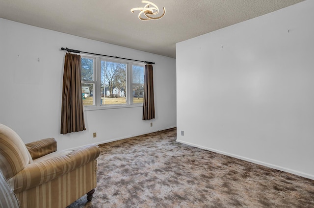 living area with a textured ceiling, baseboards, and carpet floors