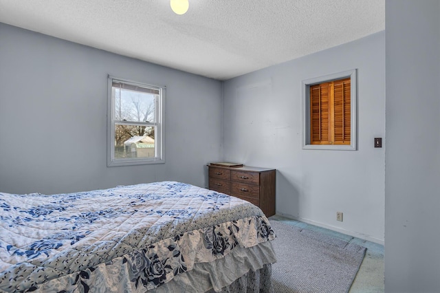 carpeted bedroom featuring baseboards and a textured ceiling