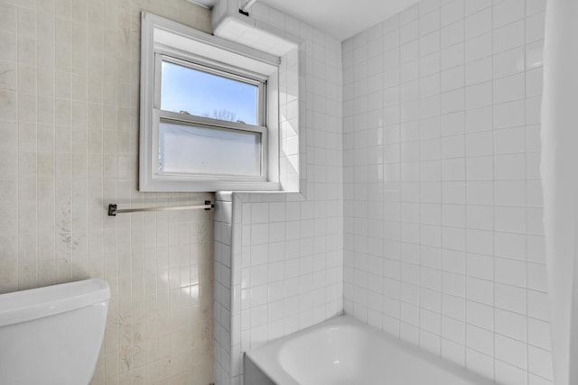 bathroom featuring toilet, tile walls, and a washtub