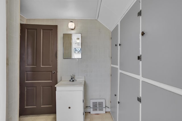 bathroom with vanity, tile walls, and vaulted ceiling