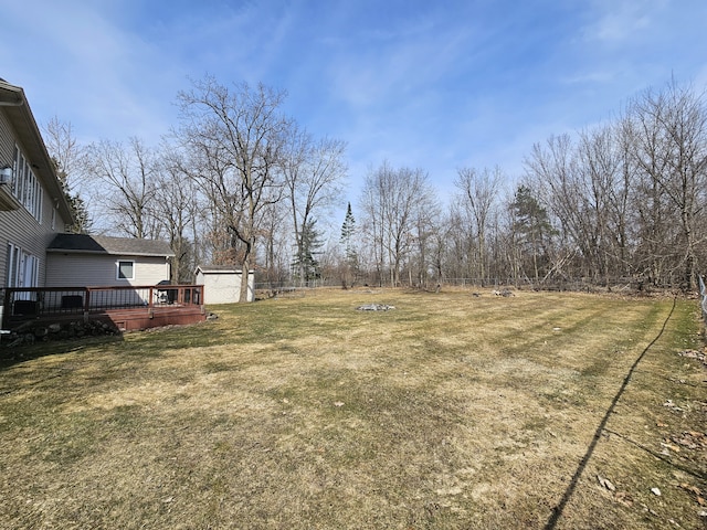 view of yard with a wooden deck and an outbuilding