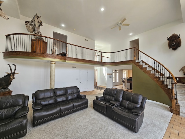 living area with visible vents, ceiling fan, stairway, recessed lighting, and a high ceiling