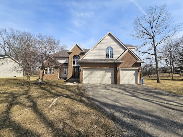 traditional-style home featuring brick siding, an attached garage, driveway, and roof with shingles