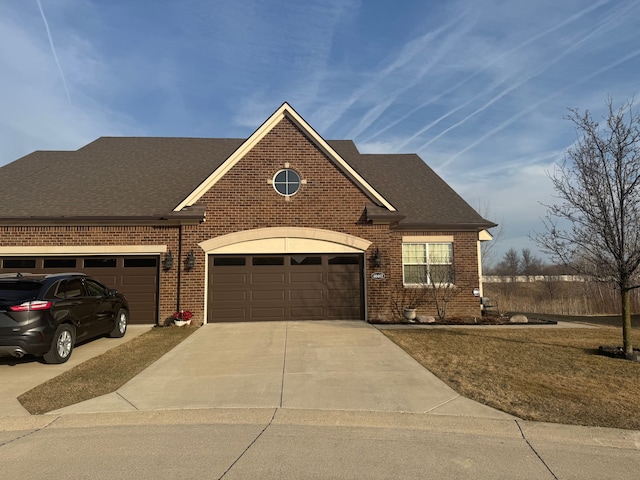 view of front of house featuring brick siding, driveway, an attached garage, and a shingled roof