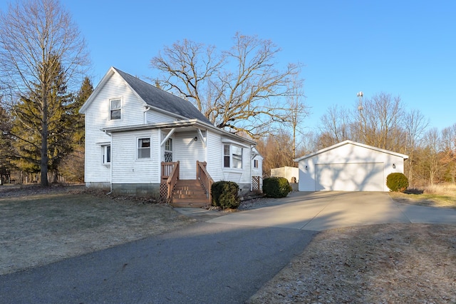 view of front of house with a detached garage and an outbuilding