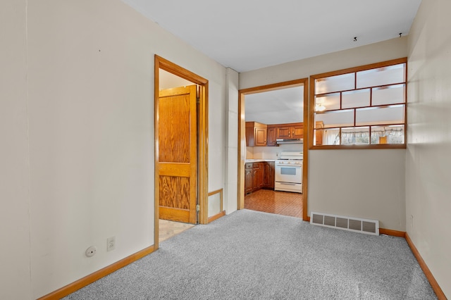 unfurnished room featuring visible vents, baseboards, and light colored carpet