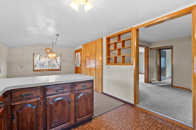 kitchen with light colored carpet, light countertops, baseboards, and vaulted ceiling