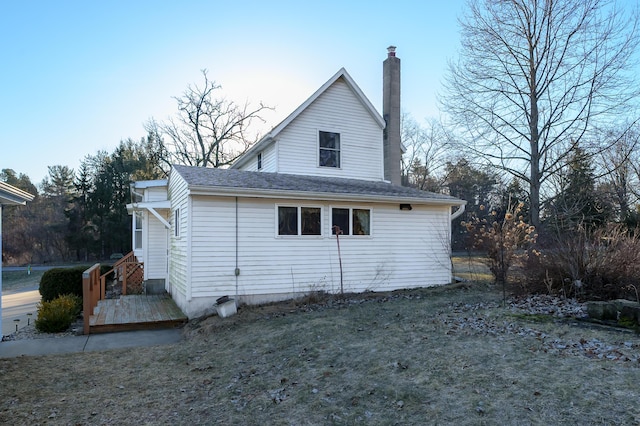 exterior space with a chimney and a shingled roof