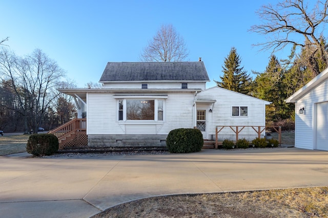 view of front of house featuring driveway and a shingled roof