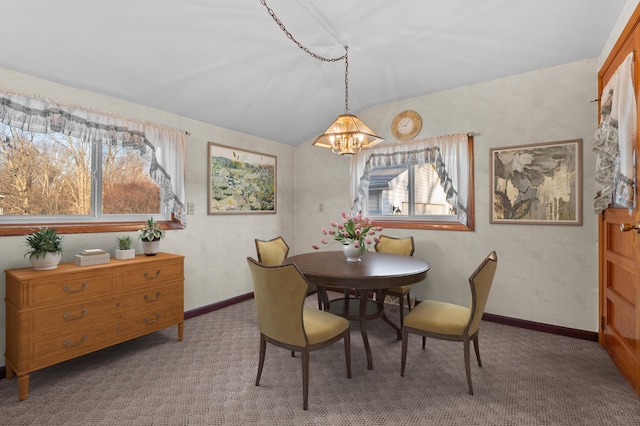 dining area featuring carpet flooring, baseboards, an inviting chandelier, and vaulted ceiling