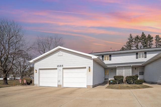 traditional-style home with an attached garage and concrete driveway