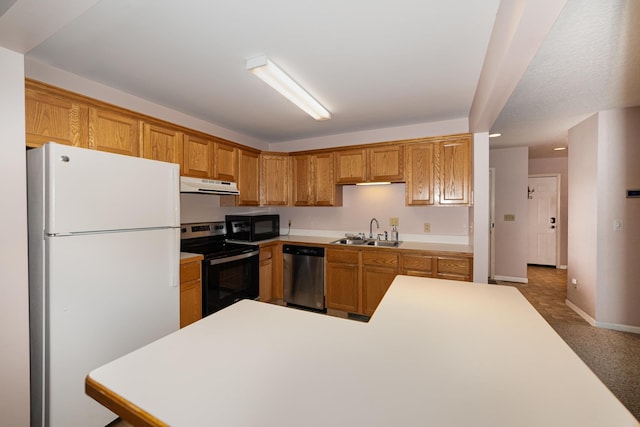 kitchen featuring under cabinet range hood, light countertops, appliances with stainless steel finishes, and a sink