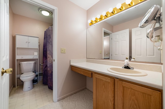 bathroom with baseboards, toilet, and vanity