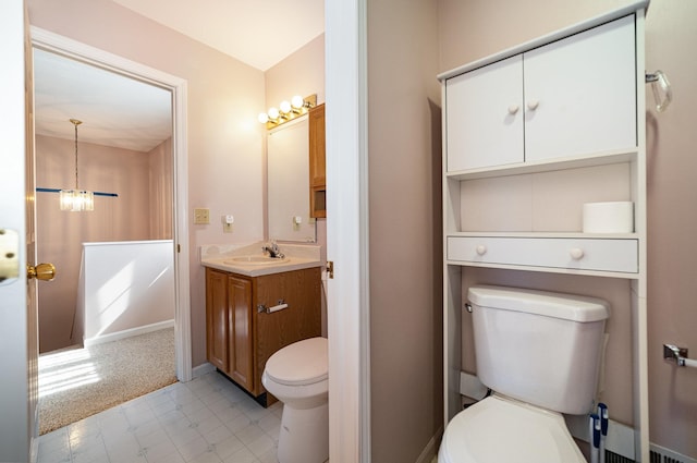 bathroom featuring baseboards, toilet, tile patterned floors, a notable chandelier, and vanity